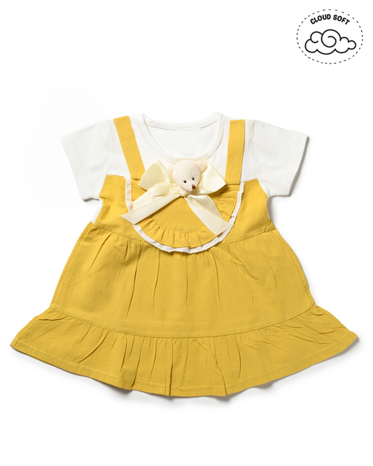 A cute yellow overall dress with a white t-shirt underneath, a trendy piece of girls fashion