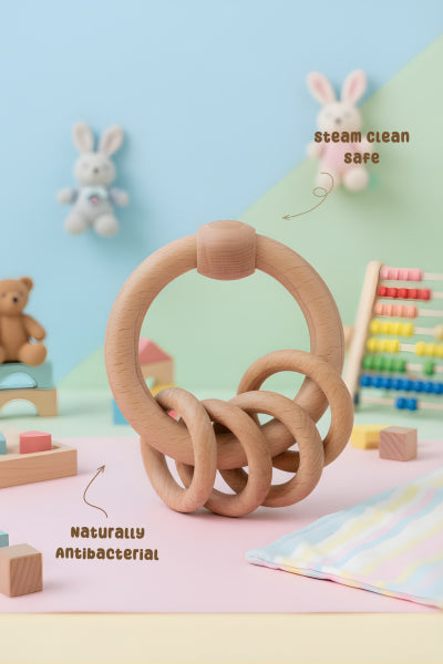 Wooden teething ring on a colorful play mat with toys and educational items in the background.