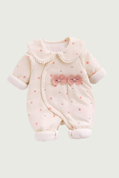 Baby romper with pink bows and polka dots on a light gray background