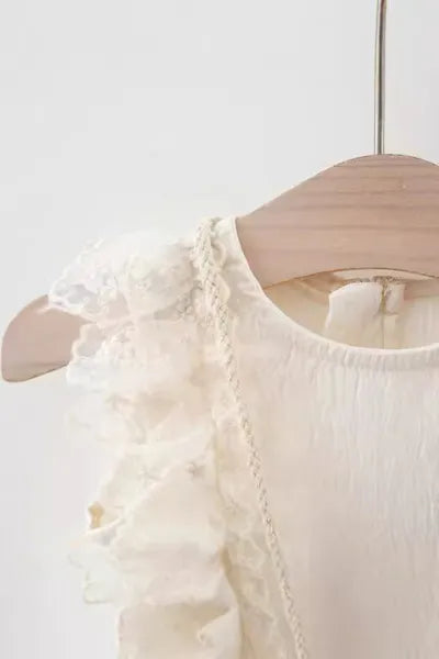 Girls kids clothing: A stylish and sweet white dress with frill details, reflecting current trends in girls fashion