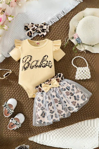 An appealing selection of new born cloths designed with girls fashion in mind, showcasing a leopard print skirt, "Babe" top, and various stylish accessories, aligning with trending clothes for girls
