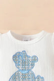 This adorable baby girl outfit includes a short-sleeved bodysuit, a cute plaid skirt with a bow, and a matching headband, a fashionable choice in new born cloths and trending in girls fashion.
