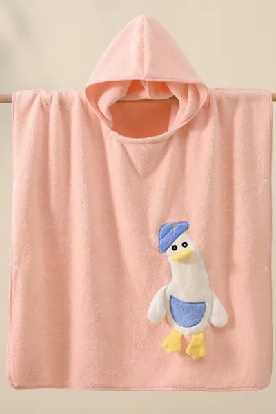 A soft, hooded pink towel with a white and blue cartoon duck applique hanging from a wooden rod