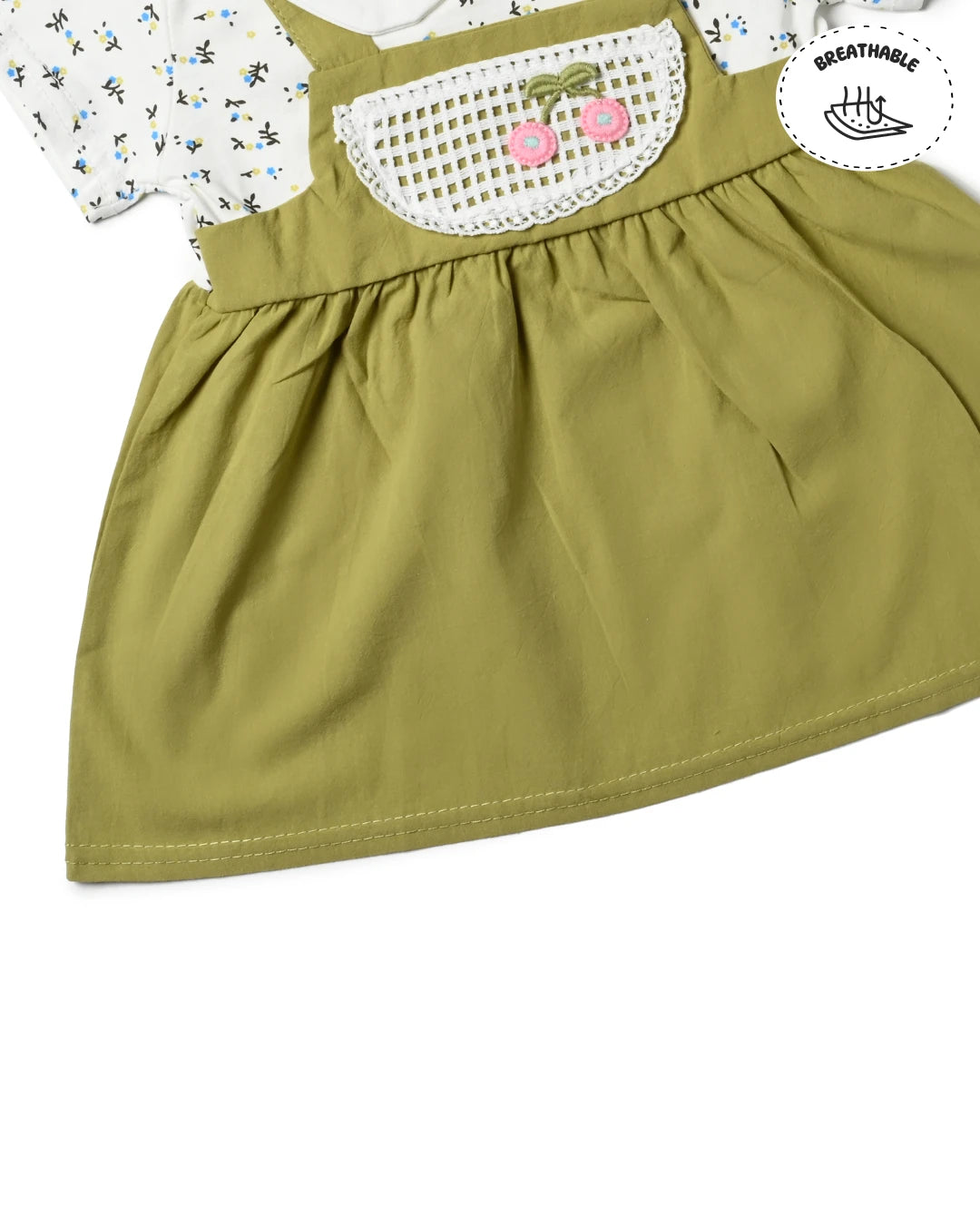 A cute green overall dress with a white t-shirt underneath, a trendy piece of girls fashion