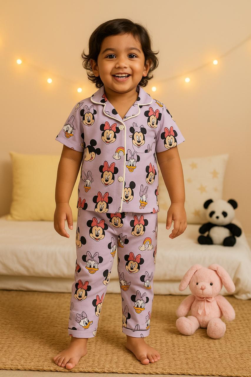 Child wearing cosy kids sleepwear pants set with cartoon characters, standing in a bedroom with soft lighting and plush toys