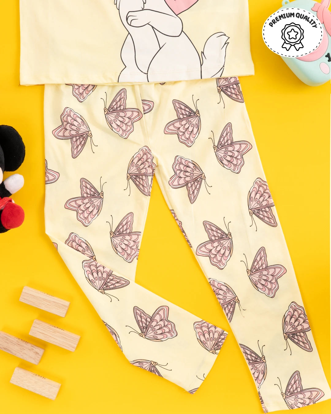 Trending clothes for girls featuring a playful cat and butterfly design on a yellow top and pants. Girls kids clothing, girls fashion, girls wear