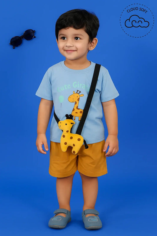 A young boy with dark hair smiles, wearing a light blue t-shirt with a giraffe graphic, mustard yellow shorts, and light blue sandals. He has a small yellow giraffe purse with black spots slung across his shoulder. Sunglasses are visible in the upper left corner against a solid blue background. A "Cloud Soft" logo is in the upper right corner.