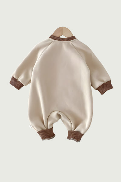 Beige baby romper with brown accents on a light gray background